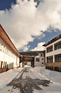 a snow covered street in front of a building at Hotel Sklárna Harrachov in Harrachov