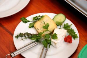 a plate of food with cheese and vegetables on a table at Stay @ Swakop in Swakopmund