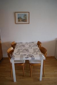 クランにあるRésidence Les Mandarins Dのテーブル(椅子4脚、白いテーブルクロス)