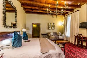 a bedroom with a large bed and a living room at Lemoenkloof Boutique Hotel in Paarl