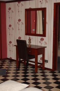 a desk with a mirror and a chair in a room at Sy Select place in Ferrières