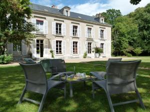 un grupo de sillas y una mesa frente a una casa en Le Grand Saint-Marc en Vendôme