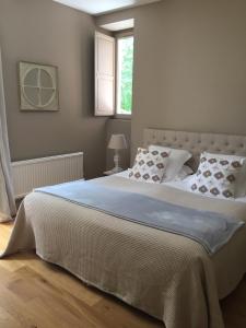 1 dormitorio con 1 cama blanca grande y ventana en EVIDENCE Maison d'Hôtes, en Mercurey