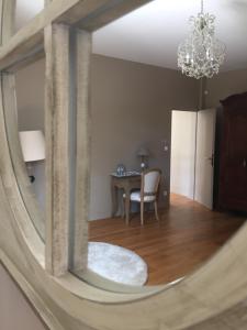 a mirror reflection of a dining room with a table at EVIDENCE Maison d'Hôtes in Mercurey