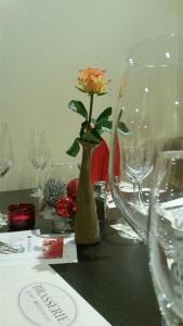 a flower in a vase on a table with glasses at Hotel Panorama Hamburg-Harburg in Hamburg