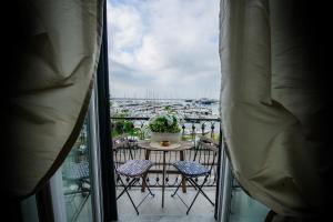 a balcony with a table and chairs and a view of a harbor at MARGHERITA's Apartment in Salerno