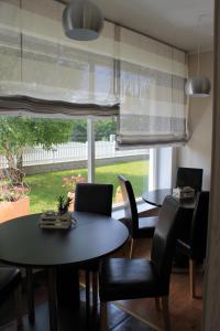 a dining room with two tables and chairs and a window at Yellow Dreamhouse in Postojna