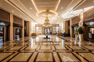 a lobby with a marble floor and a chandelier at Golden Chariot Vasai Hotel in Vasai +40 photos