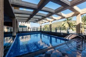 an indoor swimming pool with a pergola at Golden Chariot Vasai Hotel in Vasai