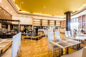 a restaurant with tables and chairs in a room at Golden Chariot Vasai Hotel in Vasai