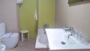 
a bathroom with a sink, toilet and bathtub at Hotel Avenida in Requena

