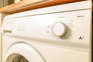 een witte wasmachine op een plank bij The Loft, Inverness in Inverness +7 foto's