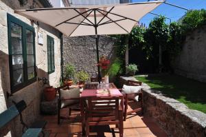 a table with an umbrella on a patio at Casa tía Amparo in Portosin