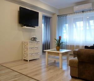 a living room with a tv and a couch and a table at VárLak Apartman in Debrecen