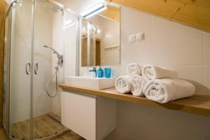 a bathroom with a sink and a shower and towels at U przyjaciol - Debki in Dębki +54 photos