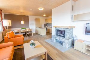 a living room with a fireplace and a kitchen at Lake Peak Apartments, Ribniško Pohorje in Ribnica na Pohorju