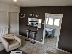 a living room with a chair and a mirror at Appartement Liartais - Accueil Chevaux - Horse Friendly in Liart