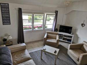 Una sala de estar con dos sofás y un televisor. en Appartement Liartais - Accueil Chevaux - Horse Friendly, en Liart