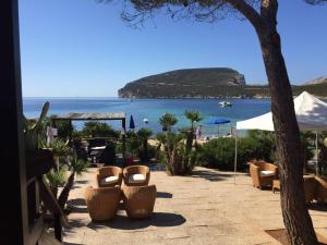 een patio met stoelen en uitzicht op het strand bij Villa Margherita in Alghero