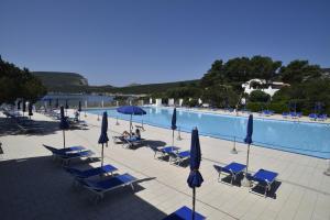 a swimming pool with lounge chairs and umbrellas at Villa Margherita in Alghero