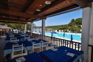 un ristorante con tavoli blu e vista sulla piscina di Villa Margherita ad Alghero