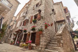 an old stone building with potted plants on it at Apartments Renaissance Old town in Budva