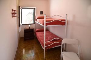 two bunk beds in a small room with a window at Villa Margherita in Alghero +18 photos