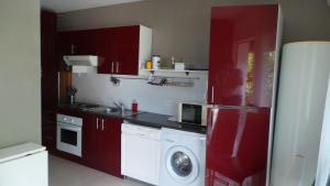 uma cozinha com armários vermelhos e uma máquina de lavar roupa em Cavone 2 em Castellare-di-Casinca