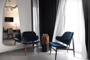 a room with three blue chairs and a mirror at Alexander Inn in Stavros