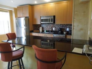 a kitchen with a counter with chairs and a refrigerator at The Eldon Luxury Suites in Washington