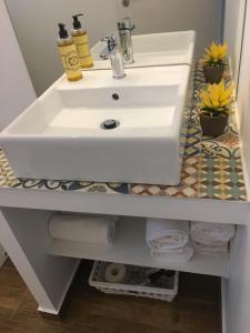 a white sink on a bathroom counter with towels at Casa do Peso 1 in Peso da Régua