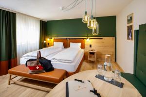 una camera d'albergo con letto, tavolo e sedie di Hotel Hirschen Wildhaus a Wildhaus