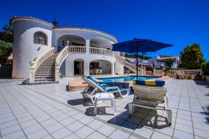 モライラにあるLa Perla - sea view villa with private pool in Morairaのプール、椅子2脚、傘1脚が備わる家