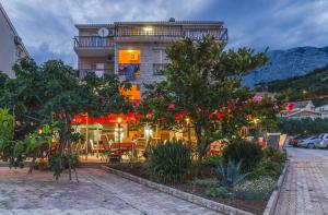 a restaurant with tables and chairs in front of a building at Apartmani Šutić in Promajna