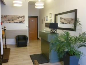 an office with a reception desk and a mirror at Hotel Beauséjour in Toulouse