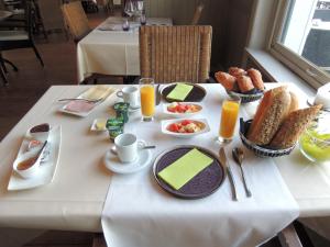 a white table with breakfast foods and drinks on it at Hotel La Tonnellerie in Spa