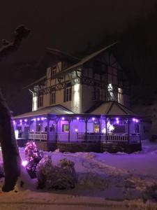 ein Haus mit lila Lichtern im Schnee in der Unterkunft Hotel La Tonnellerie in Spa