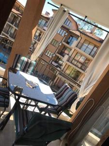 a table and chairs on a balcony with a building at Nestinarka Complex - Emili Apartment in Tsarevo