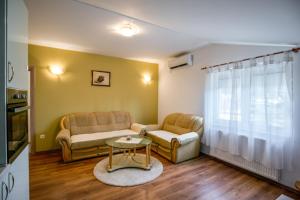 a living room with two couches and a table at Arenta Apartments in Metković