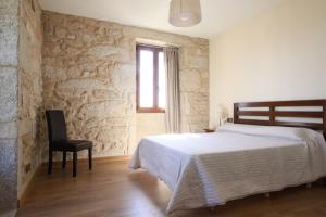 ムロスにあるCasa Area Longaのベッドルーム1室(ベッド1台、椅子、窓付)