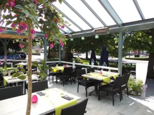 ein Restaurant mit Tischen und Stühlen unter einem Glasdach in der Unterkunft Hotel La Tonnellerie in Spa