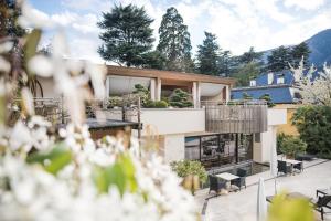 a house with a balcony and a patio at Hotel Mignon Meran Park & Spa in Merano