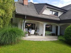 a house with a patio with a table and chairs at Pr'Simi in Golnik