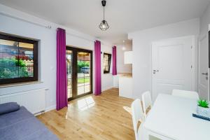 a living room with a table and purple curtains at Apartamenty Wiatr i Woda in Mikołajki