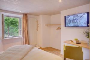 1 dormitorio con cama, escritorio y ventana en MyVerzasca Resort Ai piee, en Brione