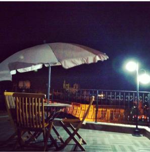 a table with an umbrella on a balcony at night at Malia Holiday Let in Famagusta