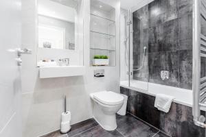 uma casa de banho com um WC, um chuveiro e um lavatório. em Roomspace Serviced Apartments- Walpole Court em Ealing