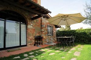 une terrasse avec une table et un parasol dans l'établissement Erboli Residence, à Cavriglia