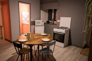 a kitchen with a table with chairs and a stove at Gîte de Lolotte et Gégé in Audeux
