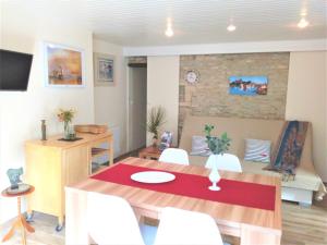 una sala da pranzo con tavolo e sedie bianche di Villa Athéna,séjour bien-être et éthique a Meuvaines